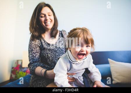 Weiblichen Kleinkind auf Mütter Schoß spielen Stockfoto