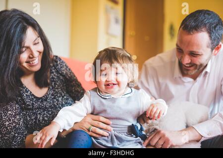 Mitte erwachsenes paar mit Kleinkind Tochter auf Sofa spielen Stockfoto