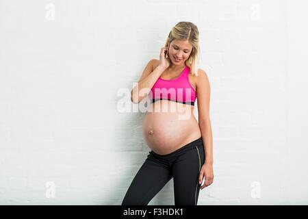 Volle Amtszeit Schwangerschaft junge Frau trägt Sportbekleidung Stockfoto