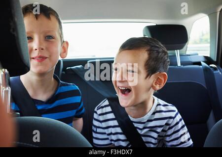 Zwei glückliche junge Brüder, die Reisen auf dem Auto Rücksitz Stockfoto