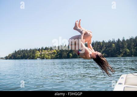 Junge Frau trägt Bikini Saltos in Lake Oswego, Oregon, USA Stockfoto