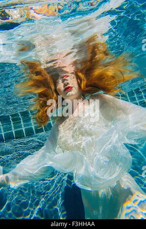 Junge Frau unter Wasser, dünne weiße Hemd Stockfoto