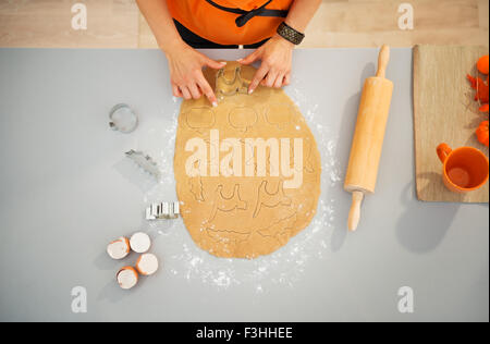 Nahaufnahme auf Hausfrau Halloween Kekse mit Gebäck Cutter ausschneiden. Traditionelles Herbstferien. Obere Ansicht Stockfoto