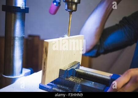 Verkürzte Sicht junger mans Hand Bohrmaschine auf Holz in Klammer in Betrieb Stockfoto