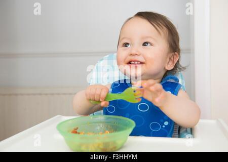 Baby-jungen Baby Essen im Hochstuhl Küche Stockfoto