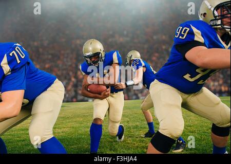 Team der Teenager American-Football-Spieler auf Stadion Spielfeld Stockfoto