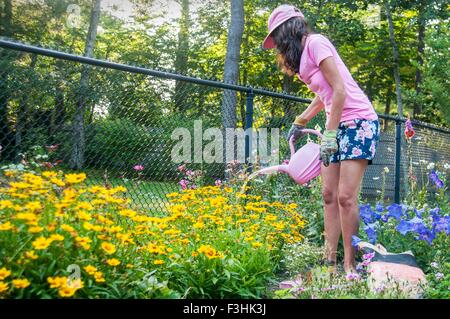 Frau, die Blumen im Garten gießen Stockfoto