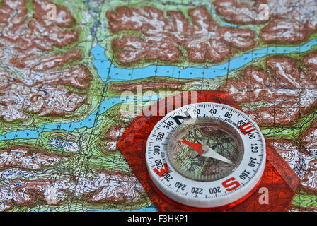 Magnetkompass befindet sich auf einer topografischen Karte. Orientierungslauf in der Wildnis Stockfoto