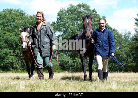 Mutter und Tochter führenden Pferde im Feld Stockfoto