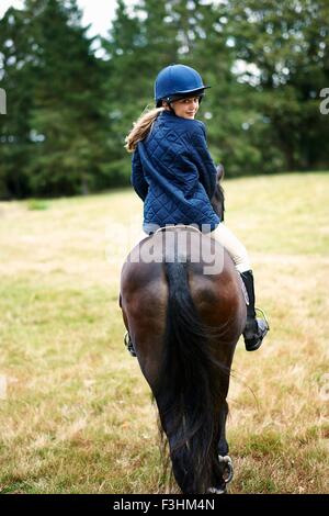 Rückansicht des Mädchen reiten im Feld Stockfoto