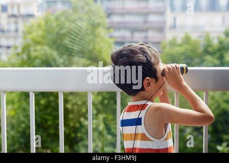 Junge Blick durch ein Fernglas auf Balkon Stockfoto