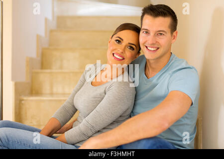 entspannte junges Paar sitzt auf der Treppe im neuen Haus Stockfoto