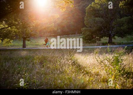 Junges Paar einfahren sonnendurchfluteten park Stockfoto