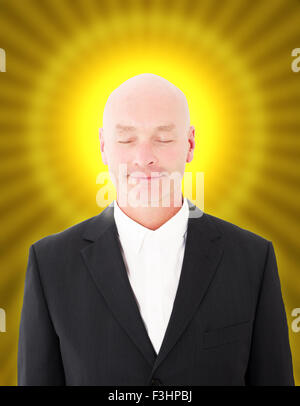 glatzköpfiger Geschäftsmann mit einem gelben Heiligenschein und geschlossenen Augen Stockfoto