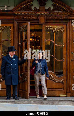 Portier am Eingang zu Fortnum and Mason Department Store öffnet die Tür für Kunden, London, UK Stockfoto