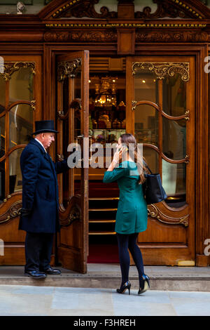 Portier am Eingang zu Fortnum and Mason Department Store öffnet die Tür für Kunden, London, UK Stockfoto