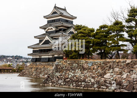 Schloß Matsumoto in Japan. Schöne schwarze Burg halten auf Stein Basis mit großer Graben. Bewölkten Himmel. Das Schloss ist ein "nationaler Schatz von Japan" Stockfoto