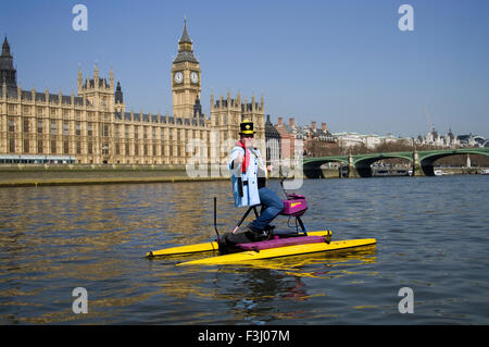 Hackney Monster Raving Loony Party Kandidaten auf schwimmenden Fahrrad auf der Themse vor dem House of Parliament im Mai 2010 Stockfoto