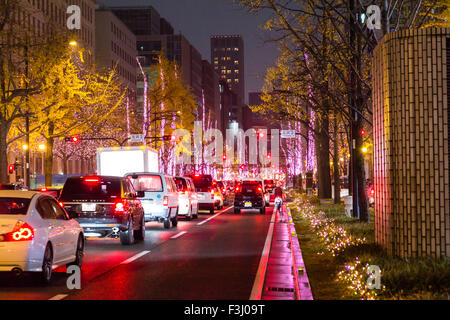 Japan, Osaka. Hikari Renaissance 2012, die Weihnachten saisonale Light Display, Hauptstraße mit Verkehr angehalten, und leuchtet gestochen dünne schmale Bäume. Stockfoto