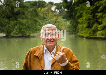 Senior mit Wildleder Jacke und weißes Hemd macht die Geste des Telefons mit hand Stockfoto