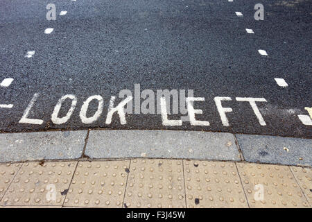 Schauen Sie links Warnung an einem Fußgängerüberweg in einer Londoner Straße. Stockfoto