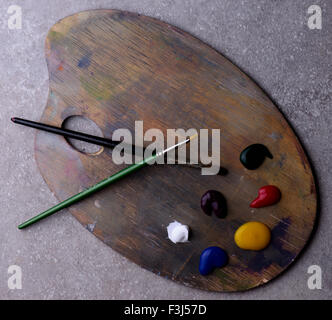 zwei Pinsel und Farben auf einem Holzkunst Farbmischpalette grauen Hintergrund Stockfoto