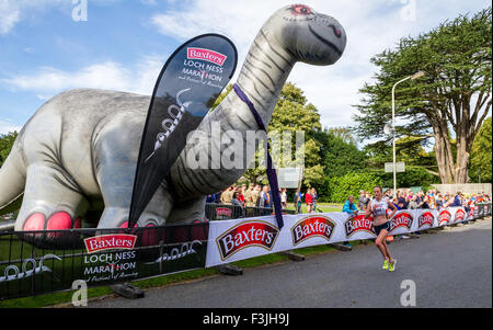 Weibliche Läufer beenden auch Loch Ness Marathon in Inverness pass eine große Blow-up-Modell der Monster von Loch Ness Stockfoto