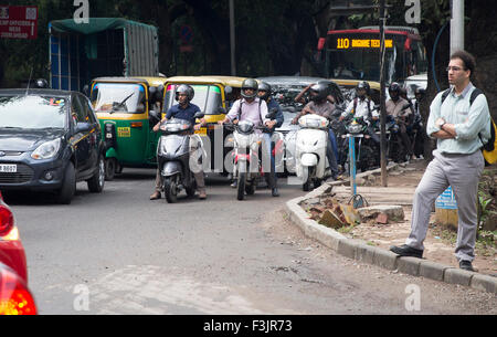 Bangalore, Indien. 6. Oktober 2015. Motorradfahrer pass Autos auf einer Straße in Bangalore, Indien, 6. Oktober 2015. Foto: Kay Nietfeld/Dpa/Alamy Live News Stockfoto