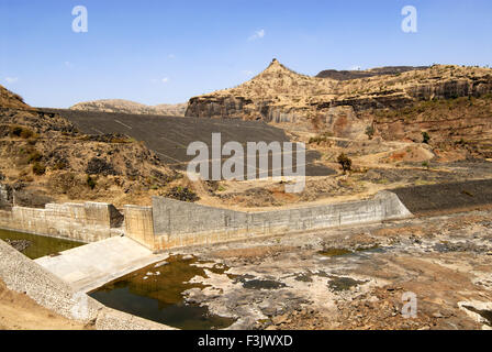 Irdischer Damm mit Steinwurf zwischen Felsbergen gebaut Chilhewadi Dorf Otur Junnar Pune maharashtra indien asien Stockfoto