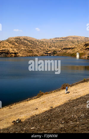 Irdischer Damm mit Steinwurf zwischen Felsbergen im Chilhewadi Dorf Otur Junnar Pune Maharashtra indien asien gebaut Stockfoto