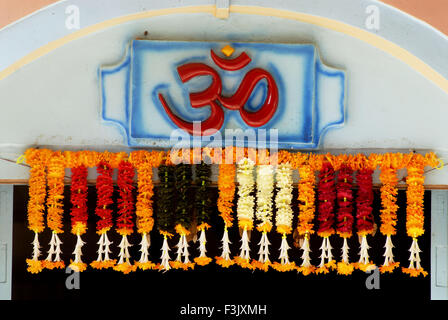 OM rote Farbe kosmische Schöpfung heiliges Wort Hindu Girlande Blumen Shri Dasabhuj Lakshmi Ganesh Tempel Hedvi Guhagar Ratnagiri maharashtra indien asien Stockfoto