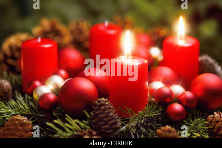 Studioaufnahme von einen schönen Adventskranz mit Kugeln und zwei brennende rote Kerzen Stockfoto