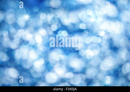 Aus der Fokuslichter erstellen einen blauen Bokeh-Hintergrund mit hellen Highlights, ideal für Weihnachten Stockfoto
