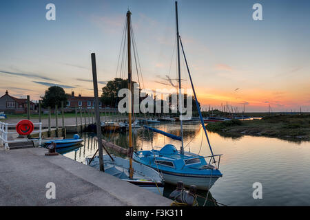 Sonnenuntergang über Segeln Boote vertäut am Kai bei Blakeney an der Küste von Norfolk Stockfoto