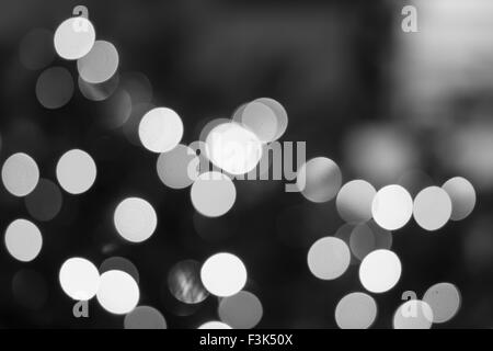 Erstellt durch eine Reihe von schwarzen und weißen Bokeh Hintergrund unscharf gestellt Weihnachtsbeleuchtung. Stockfoto