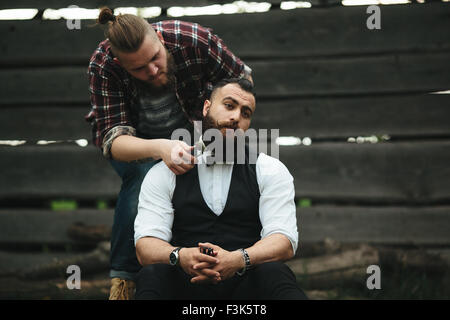 Barbier rasiert ein bärtigen Mannes Stockfoto