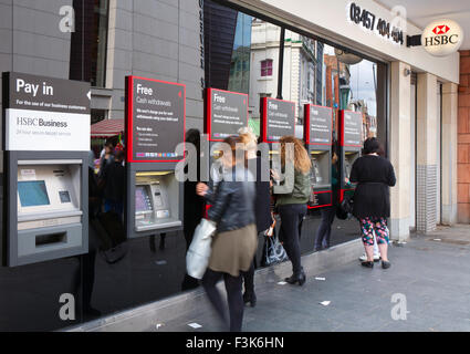 Reihe von Kunden und Geldautomaten oder Loch-in-der-Wand Maschinen außerhalb der HSBC Banken, Liverpool, Merseyside, UK Stockfoto