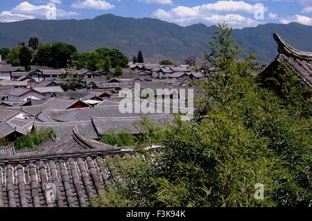 Lijiang, China: Blick über den schiefergrau gefliest Dach Jahrhunderte alten Naxi Häusern zu fernen Bergen Stockfoto