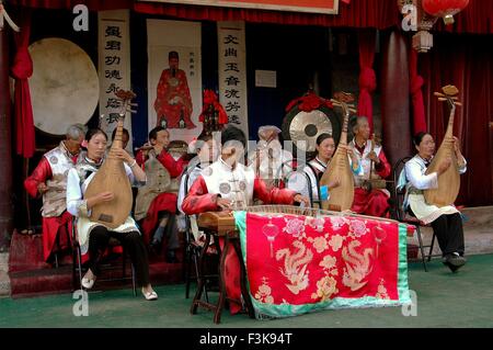 Lijiang, China: Ein Orchester-Ensemble von Musikern in traditioneller Naxi Menschen Kleidung, geben ein Konzert im Haus von Mu Stockfoto