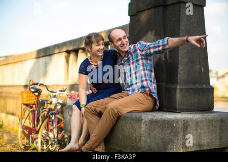 Junge Brautpaar sitzt auf einer alten Sommer-Promenade. Stockfoto