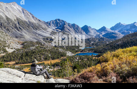 Wanderer am Aussichtspunkt neben der Mono Pass Trail entspannende sieht kleine Seen-Tal im Rock Creek Canyon in der östlichen Sierra Stockfoto