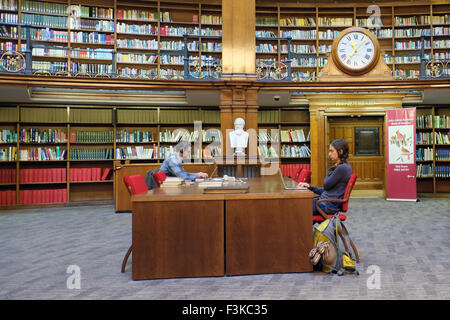 Ein Bild von der Innenseite von Liverpools berühmte Studie Picton Bibliothek mit Studenten, gestapelten Regalen, Uhr & verzierten Beschlägen, Liverpool, Merseyside, UK Stockfoto