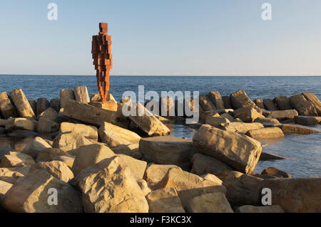 Antony Gormley lebensgroße Eisen Skulptur eines menschlichen Figur stehend an der felsigen Ufer von Kimmeridge Bay, Dorset, England, Vereinigtes Königreich. Stockfoto