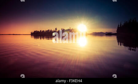 Sonnenuntergang von einer Insel aus den Südosten Alaskas mit Blendenfleck und Färbung. Stockfoto