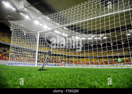 Big and furry sport microphone on a soccer field behind the goal net Stockfoto