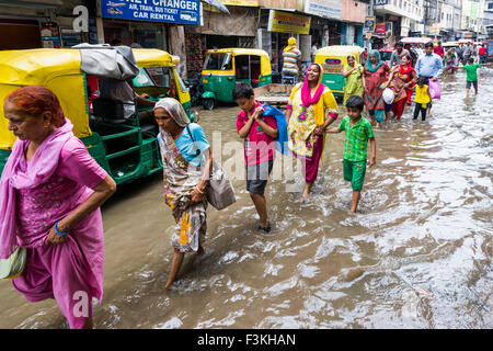 Viele Menschen und Zyklus Rikschas sind durch die überschwemmten Straßen der Vorstadt paharganj nach einem heftigen Monsun-regen Stockfoto