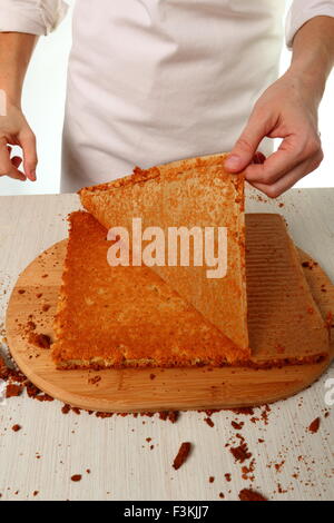 Montieren. Schneiden Kuchen auf Layern. Herstellung von Schokolade Haselnuss Baiser Kuchen Stockfoto