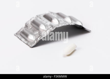 Eine silverish Paket mit Medizin Zäpfchen, ausgepackt, auf einem weißen Tabelle angezeigt Stockfoto