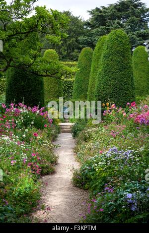 Hübsche Blumenbeete und abgeschnittene Eiben, England. Stockfoto