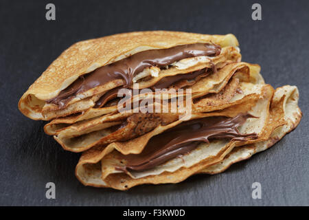 dünne Crepes oder Blinis mit Schokoladencreme Stockfoto